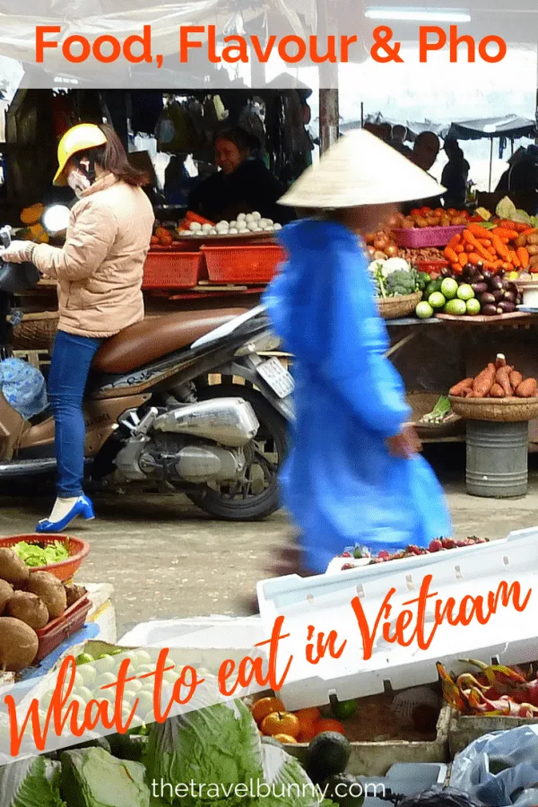 Man in Vietnamese hat walking through food market