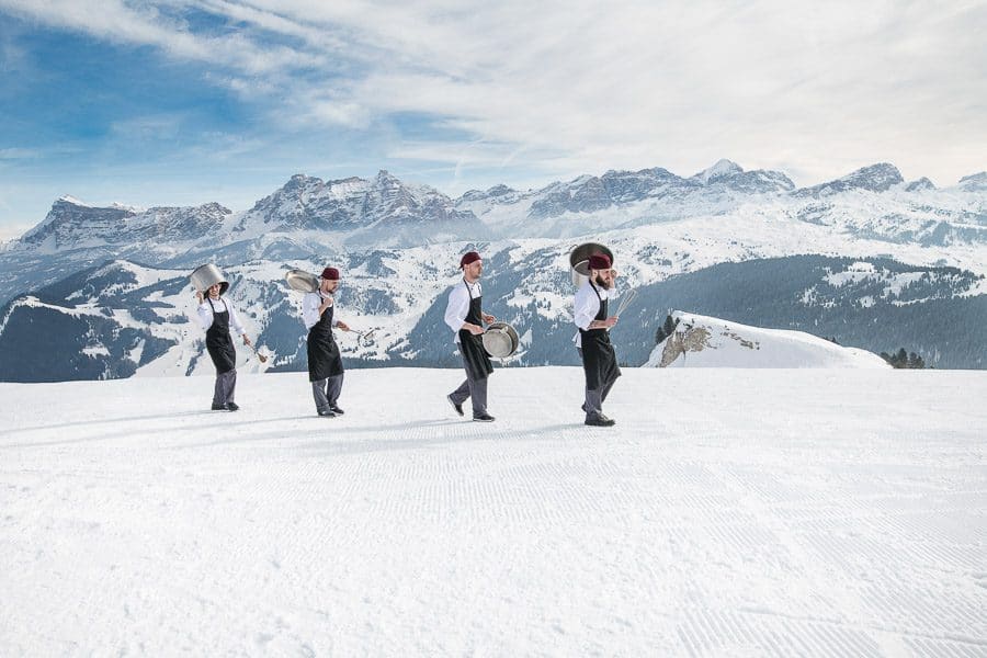 four chefs on the snow with mountain backdrop
