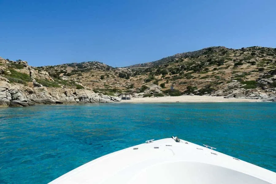 Boat in turquoise waters with beach in distance