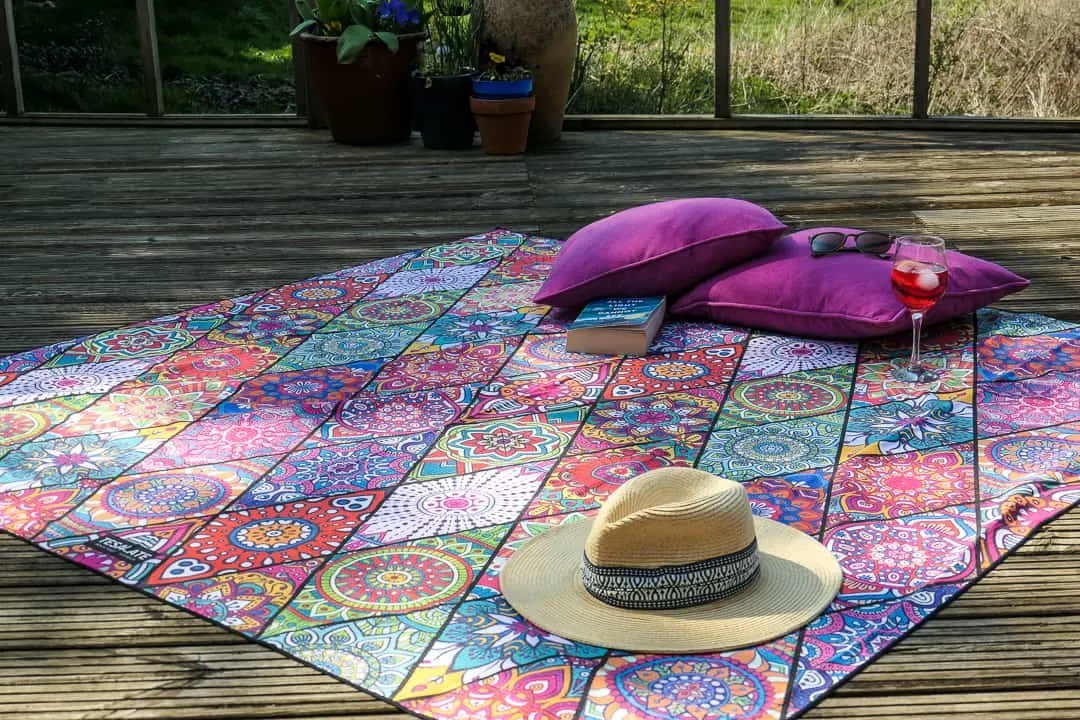 Colourful beach towel with hat and pink cushions