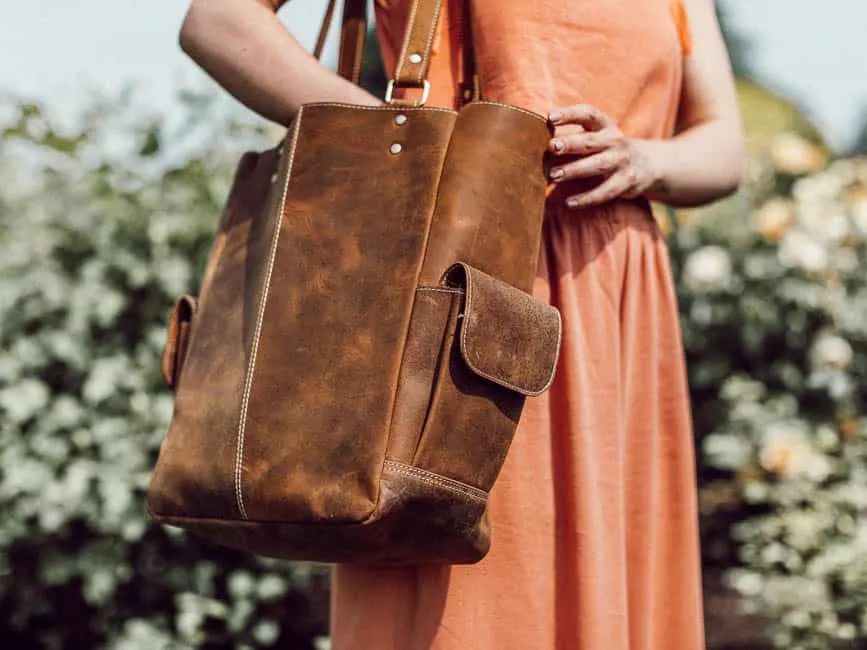 woman holding brown leather tote bag