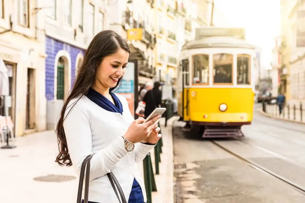 What is an eSIM. Data roaming in Europe - woman on mobile in Lisbon using eSIM