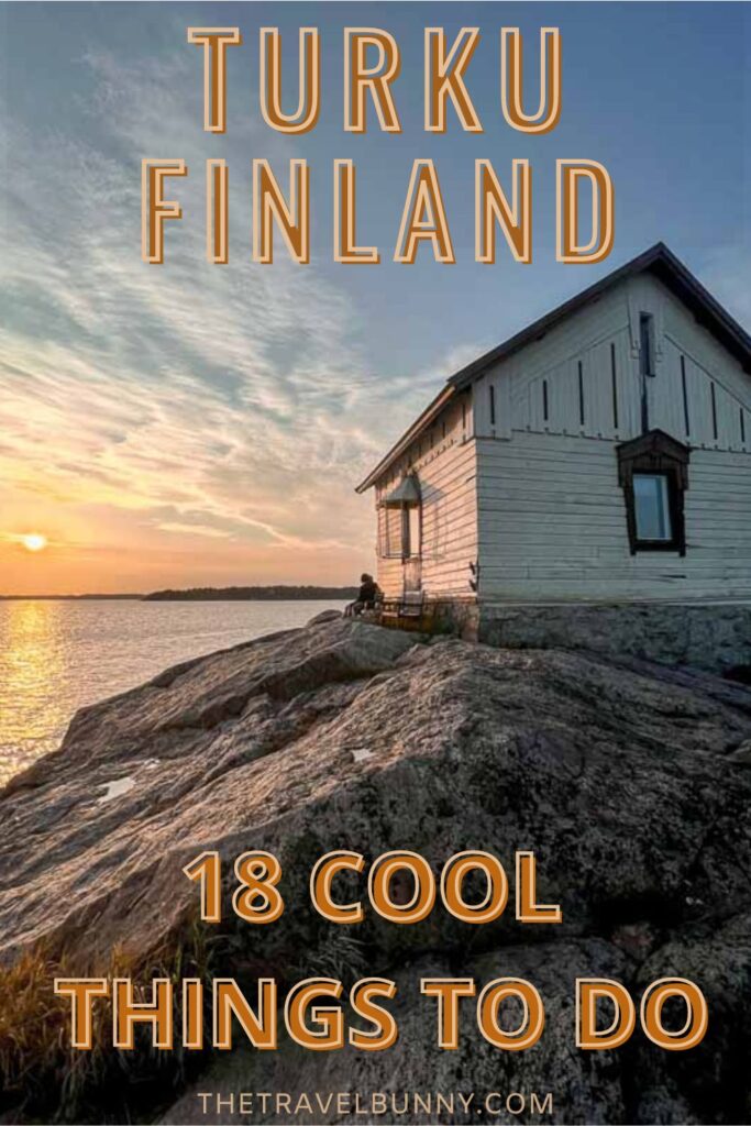White wooden hut on a small rocky island as sun sets on the horizon in Turku, Finland