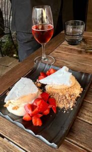 Dessert red berries, meringue and biscuit crumb with a glass of rose wine