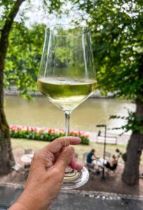 Glass of white wine at Oobu Turku with Aura River in the background