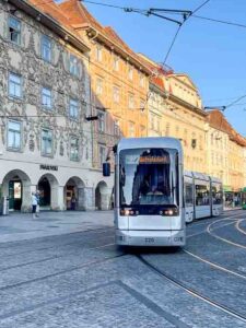 Electric tram passing Baroque buildings in Graz, Austria