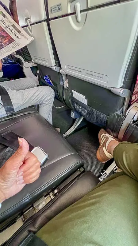 free airline seat next to passenger doing thumbs up sign