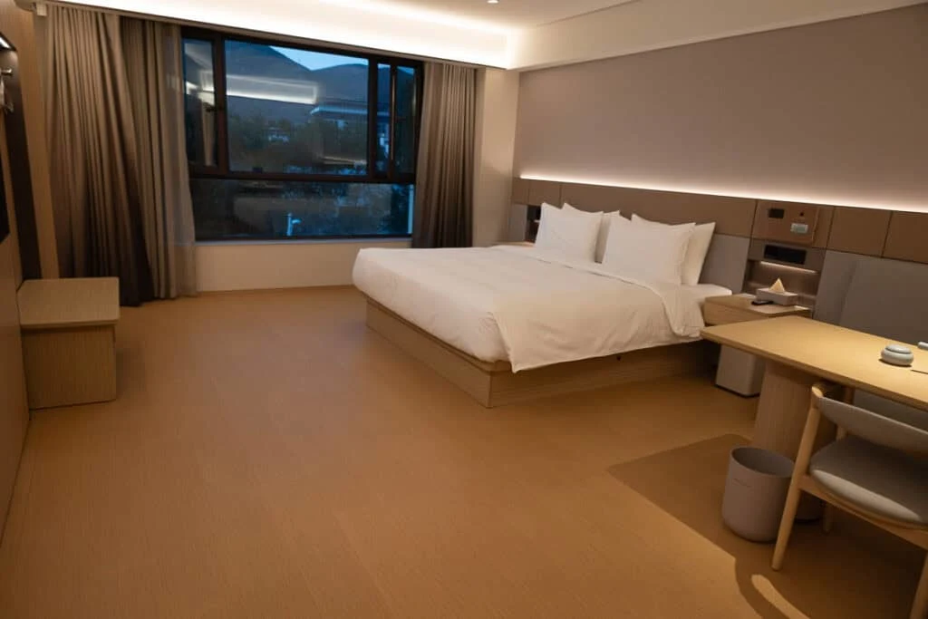 Modern hotel room at Ji-Hotel Yushu featuring a large bed, a wooden desk, and a window.