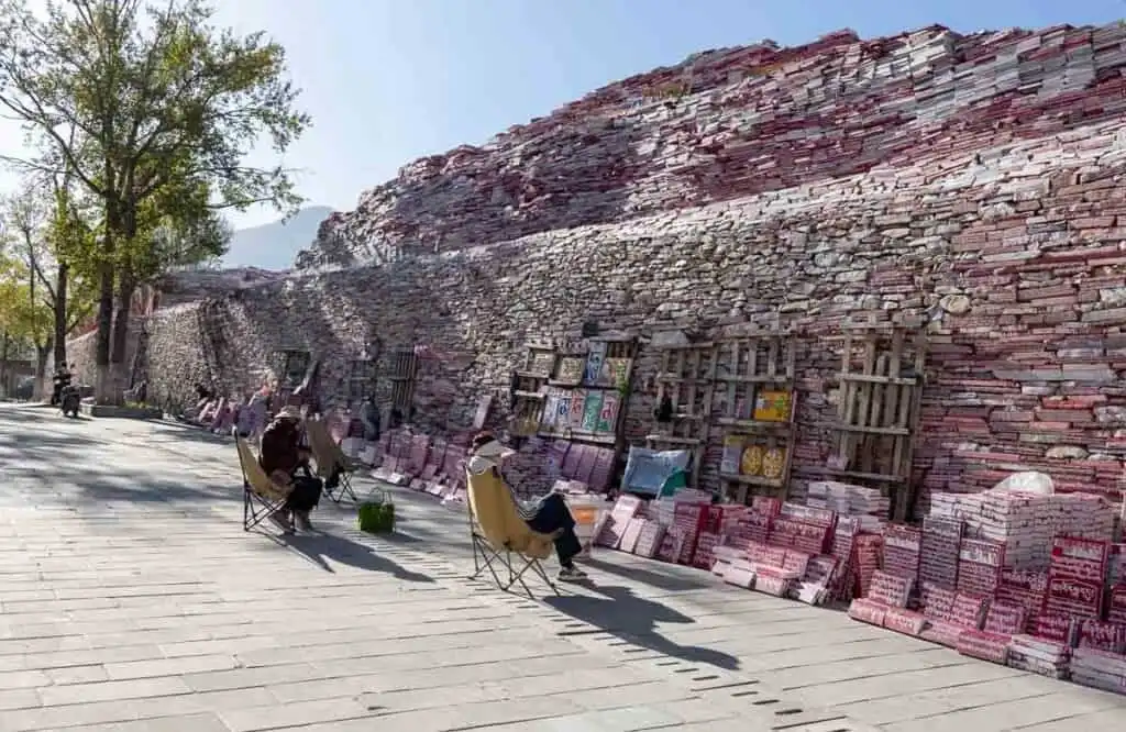 Mani stones for sale at Jiana Mani Stone City with the pile of mani stones in the background

