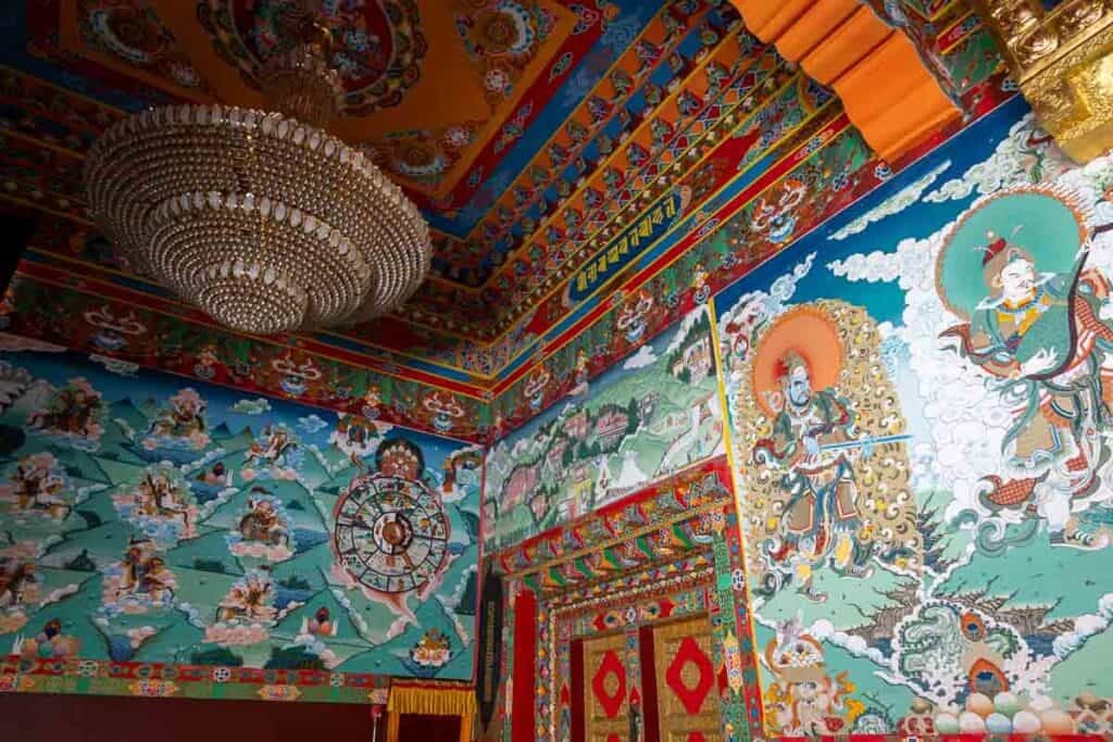 Vibrant murals and an ornate chandelier adorn the richly decorated interior of Jiegu Monastery in Yushu, China.