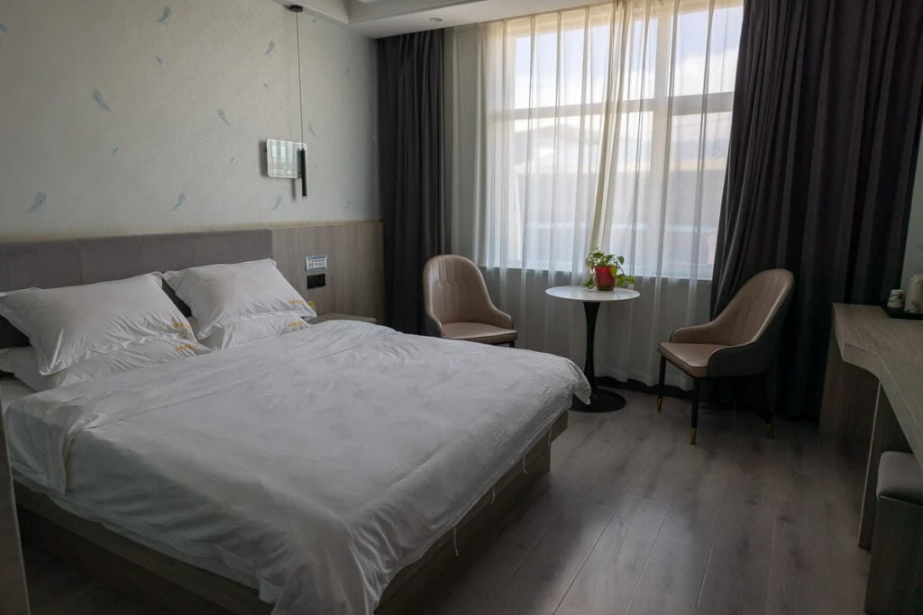 Bright hotel room at Zhaling-Lake-Hotel-Maduo with a bed, window, and seating area.