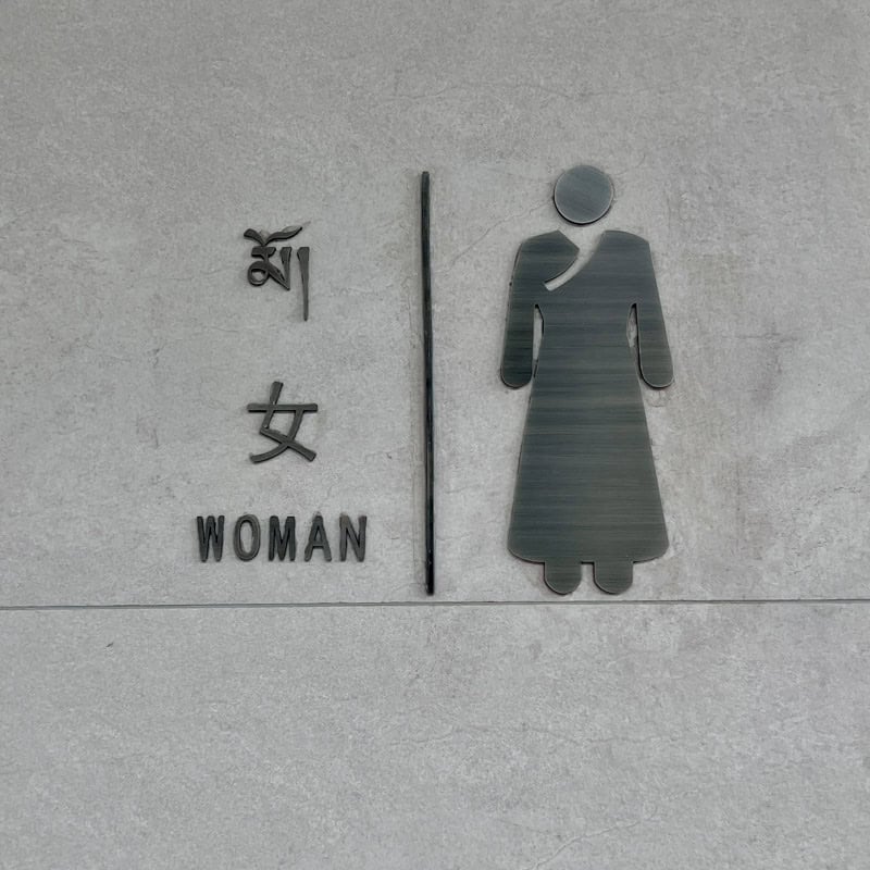 Toilet symbol in China with the word woman in English and in Chinese
