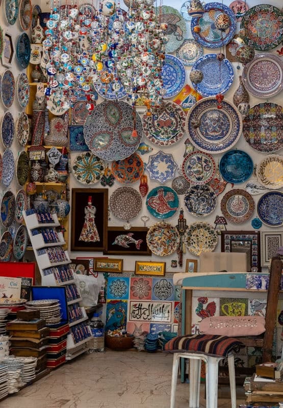 A shop displays Turkish souvenirs from ceramics and mats to embroidered pictures and hanging chimes