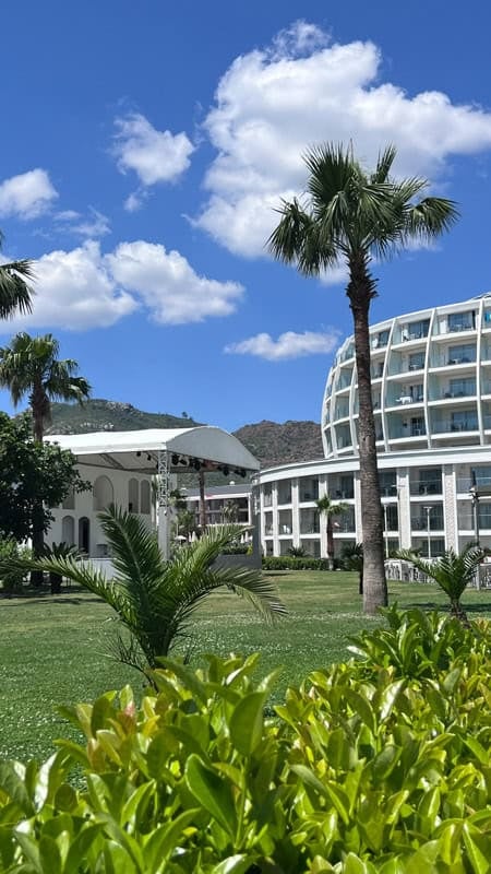 D Maris Bay hotel in Datça, Turkey, with its distinctive curved architecture, palm trees, and lush grounds.