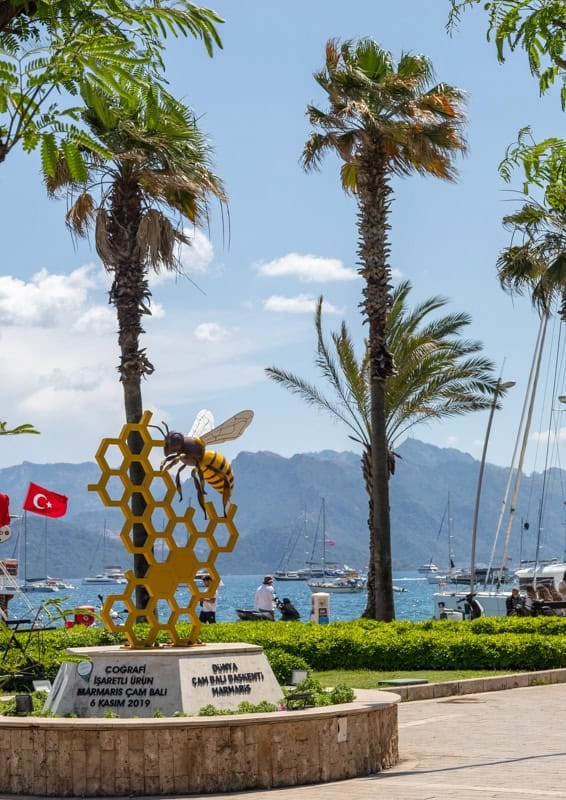 Palm trees, low hedges and a honey bee with honeycomb artwork on Marmaris seafront