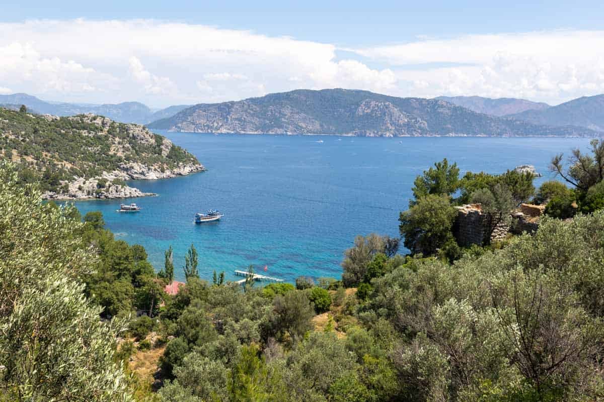 Views of Türkiye's turquoise coastal waters surrounded by pine-clad hills