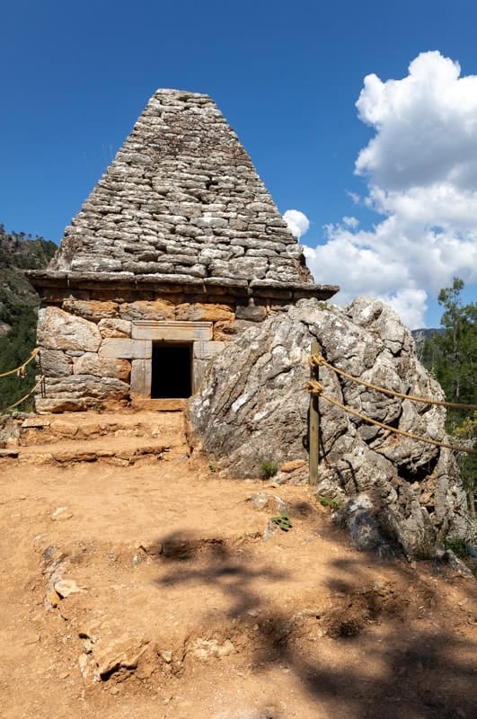 Ancient stone pyramidal Tombeau du Géant in Cévennes National Park, France, built into a rocky outcrop.