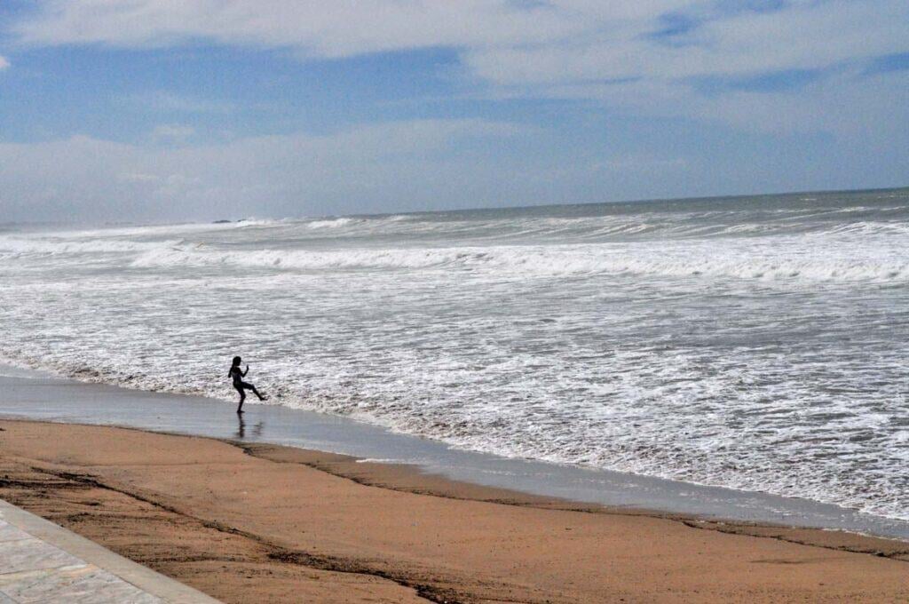 A girl plays at the water's edge on Agadir beach
